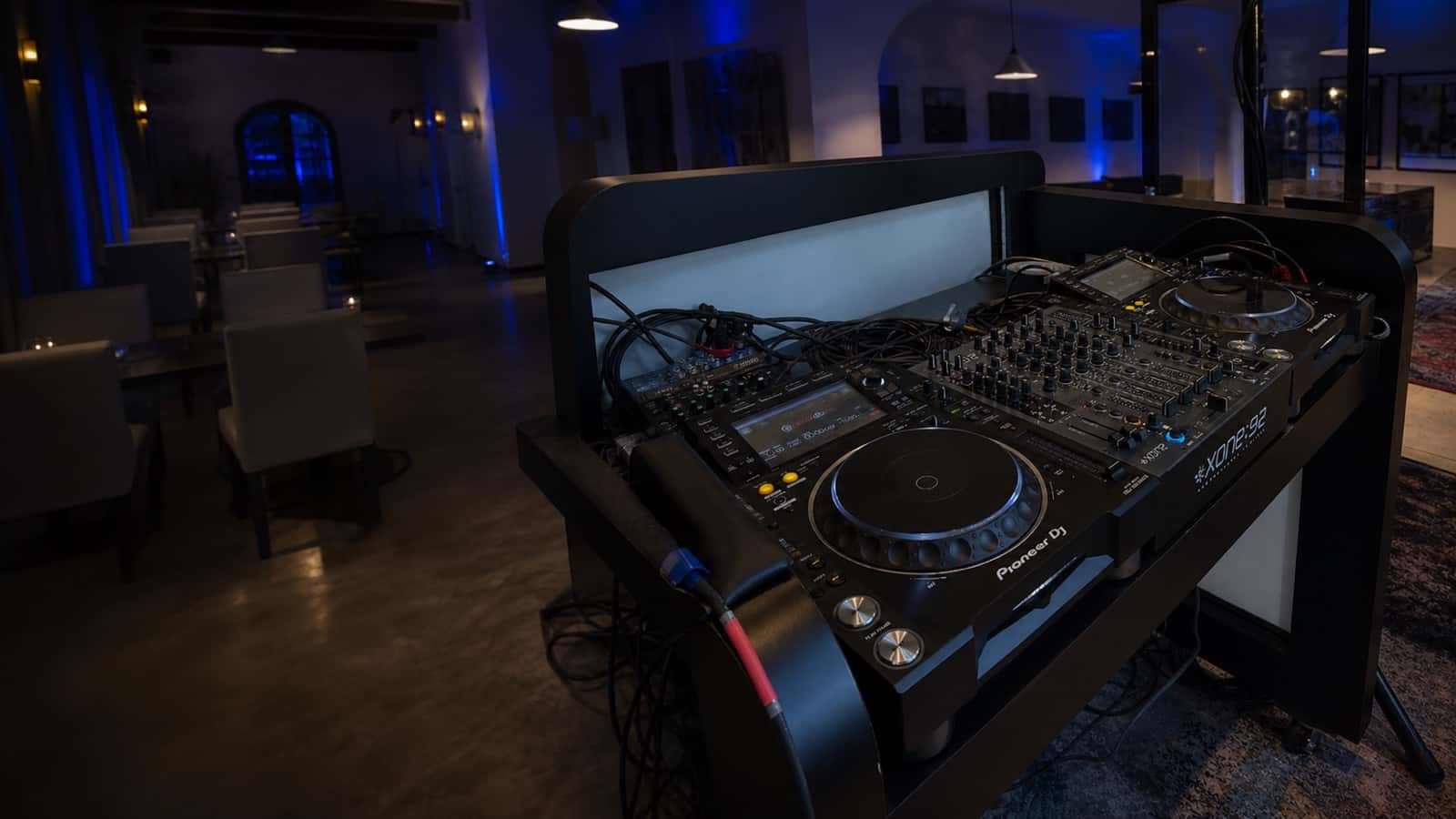 Two DJ players and a central mixer set up in an event booth