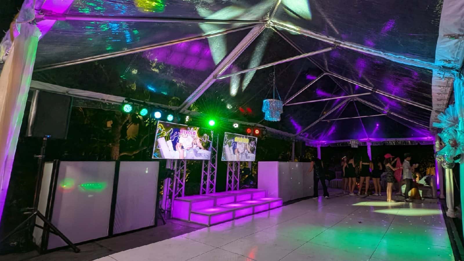 LED wash fixtures adding green, purple, and blue color around an event dance floor