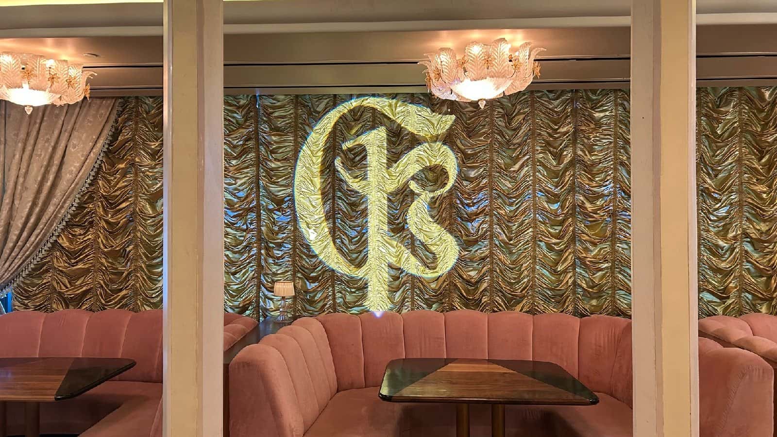 Circular custom monogram projected onto a pleated indoor backdrop