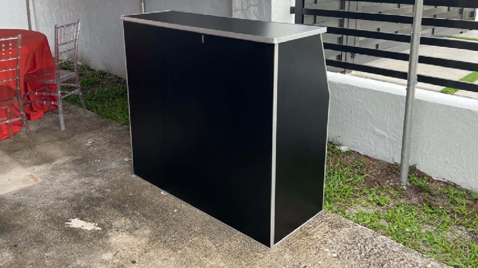 Black portable bar set up beneath an outdoor covered area