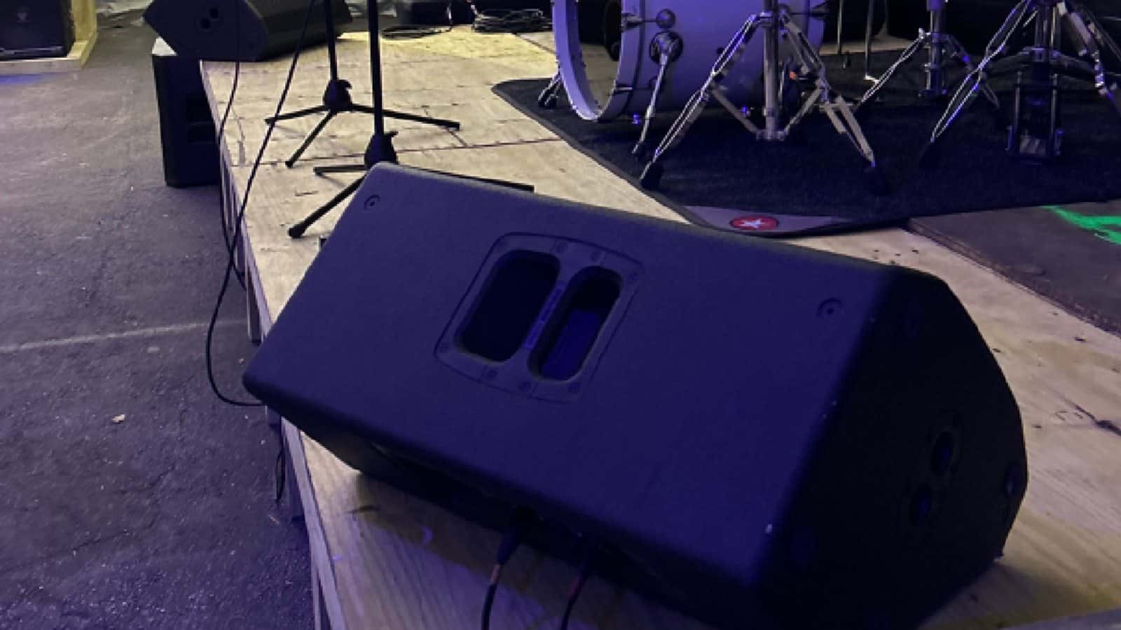 Floor wedge monitor positioned at the front of a live stage