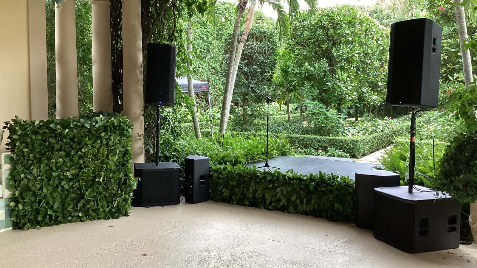 Outdoor speaker setup with two JBL subwoofers beneath top speakers