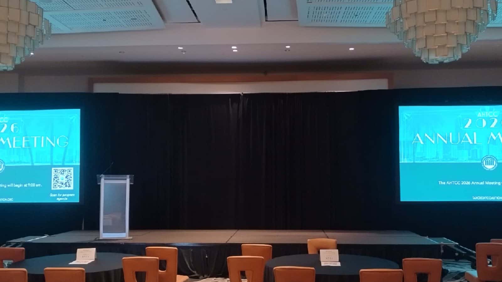 Black pipe and drape installed behind a conference presentation stage