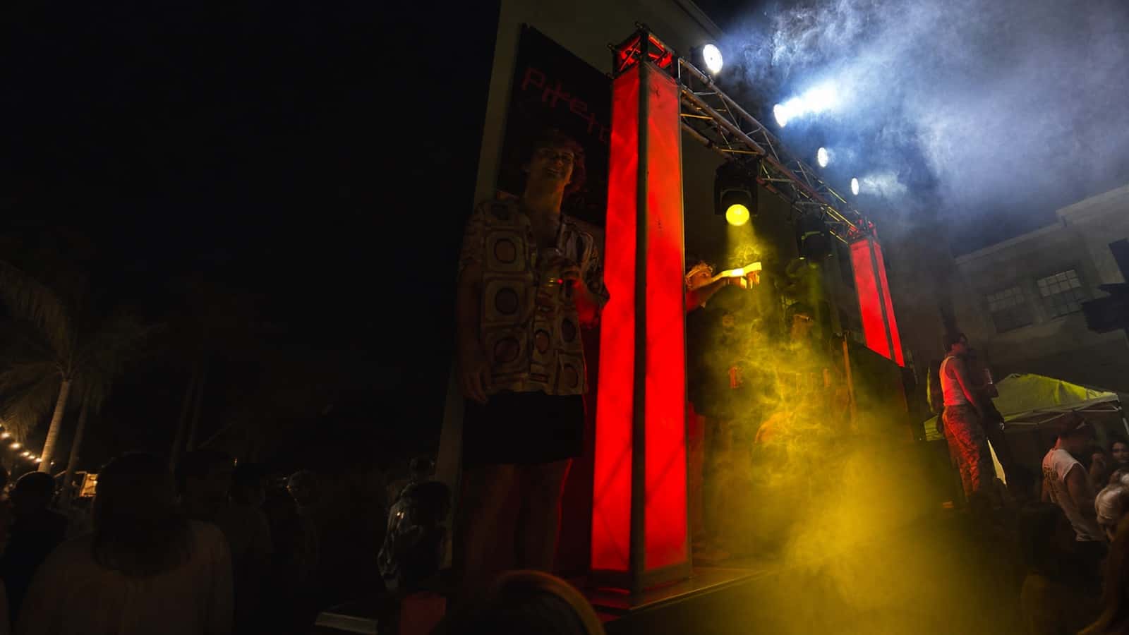 Red-lit truss goalpost supporting event lighting at an outdoor show