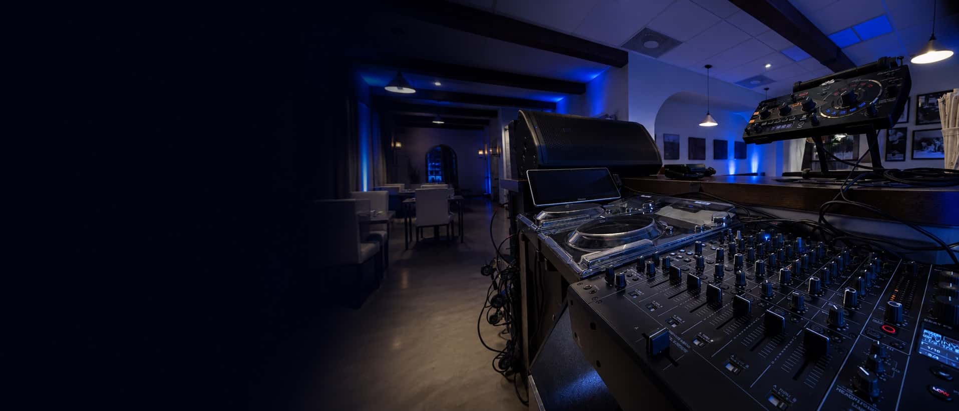 Professional DJ mixer, media players, and monitor speaker at a Miami event venue