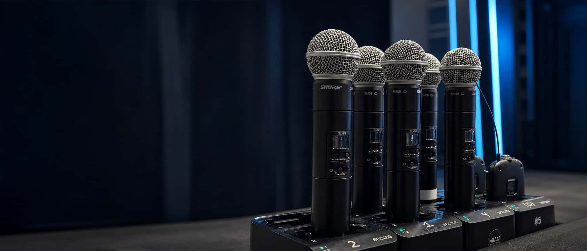 Shure wireless handheld microphones charging at a Miami Sound Rental event