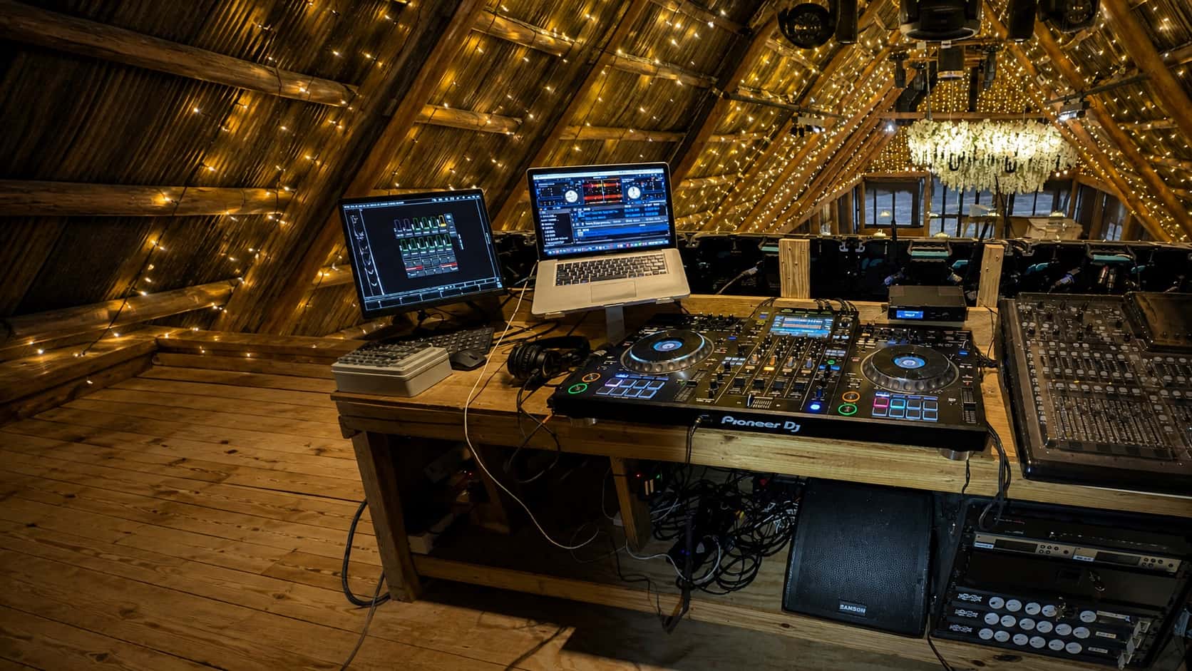 Pioneer DJ controller, mixer, laptop, and monitor speaker at an Orlando event venue