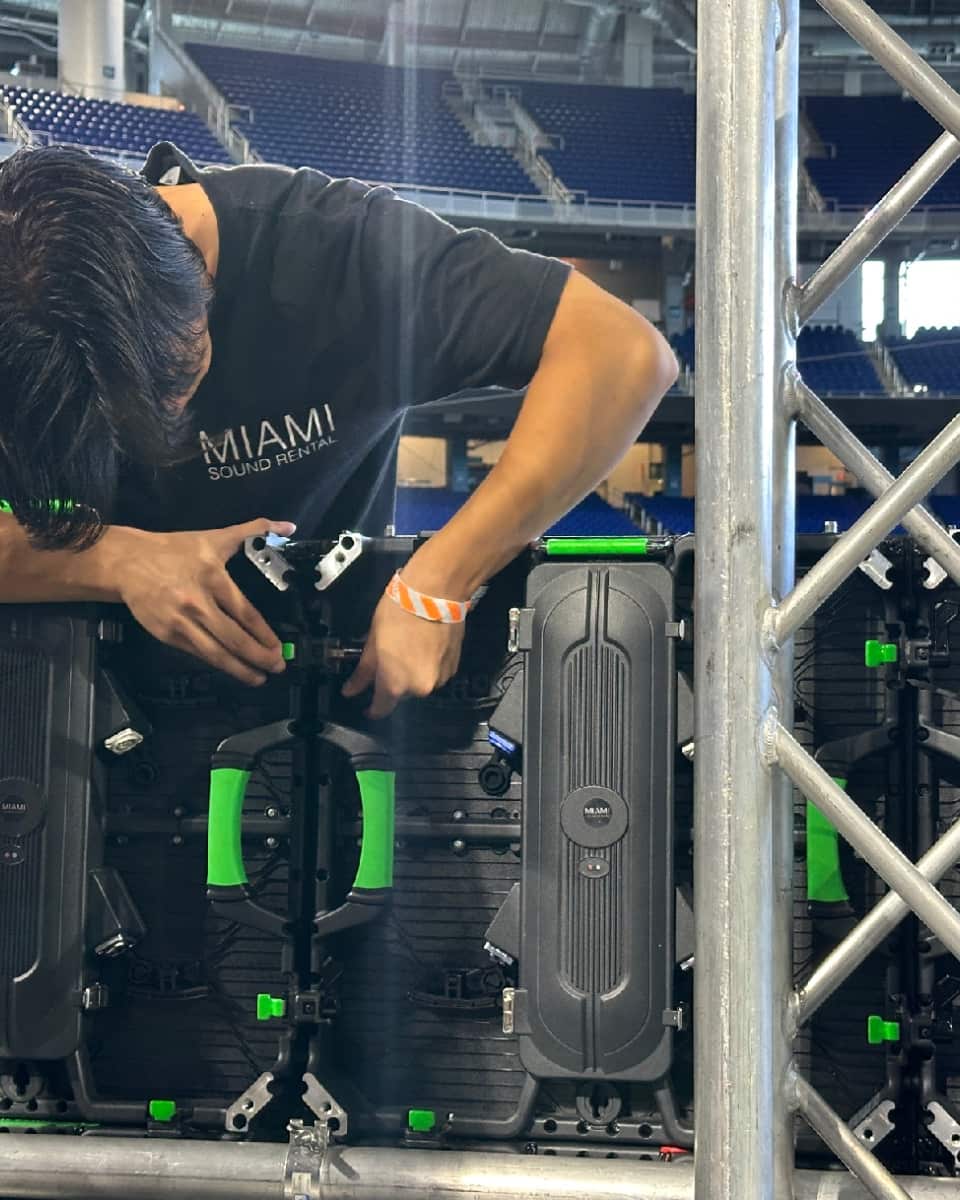 Technician assembling and testing modular LED video wall panels