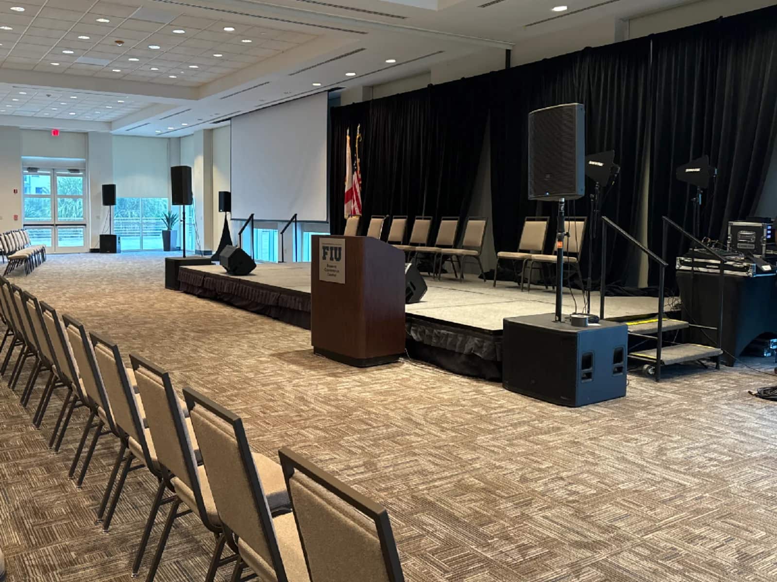 Modular presentation stage with podium, stairs, seating and sound system in a South Florida conference venue