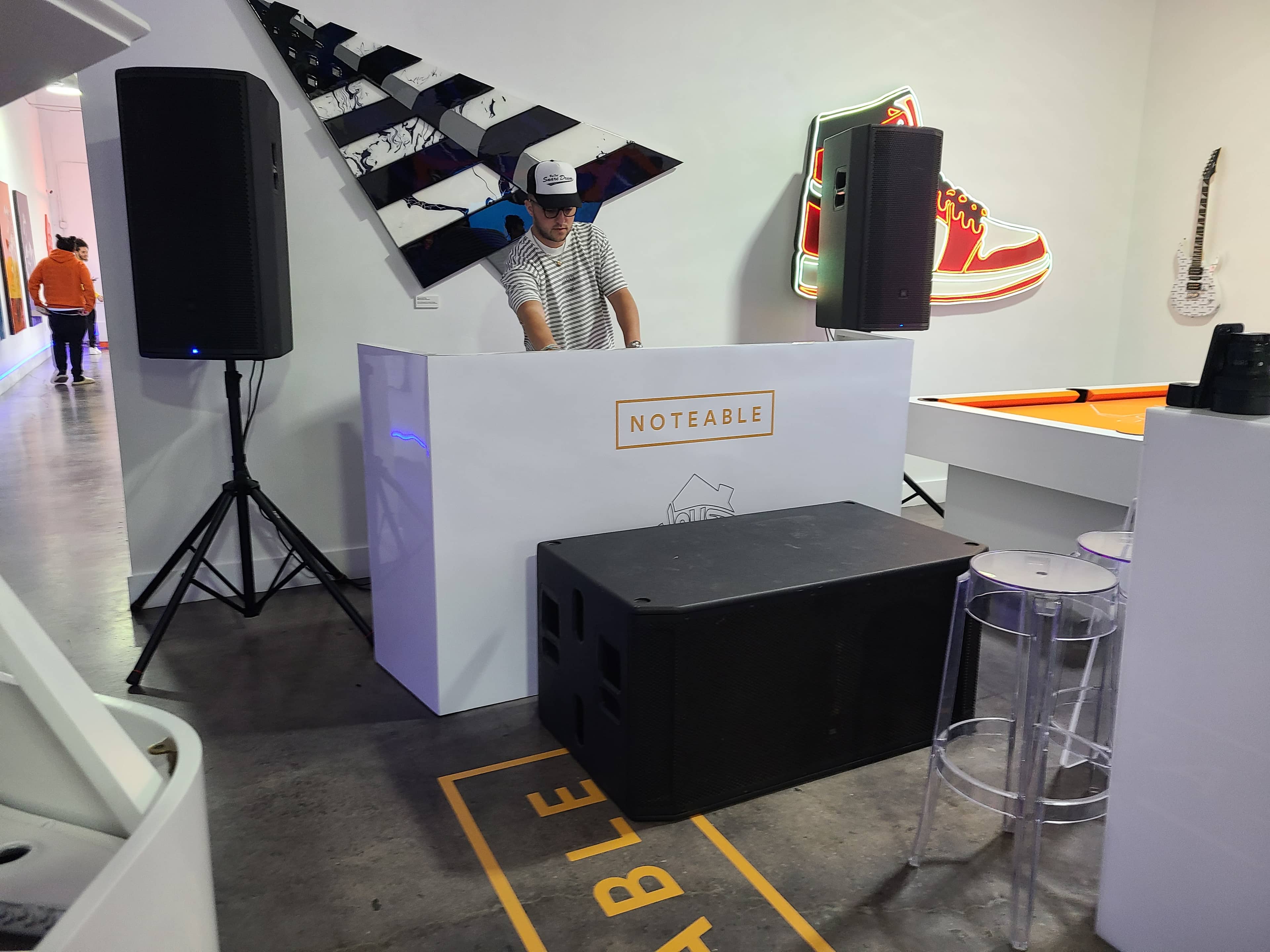 DJ performing behind a booth with a professional sound system at a real Miami event
