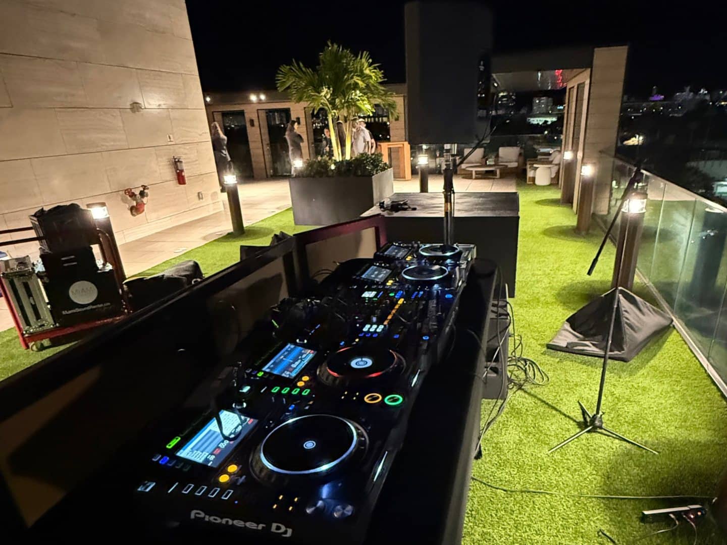 DJ mixer installed in an illuminated rooftop event setup