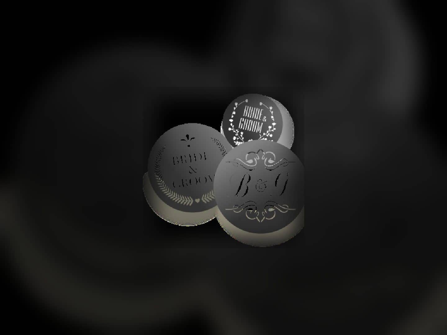 Three round custom metal gobos with cutout monogram designs
