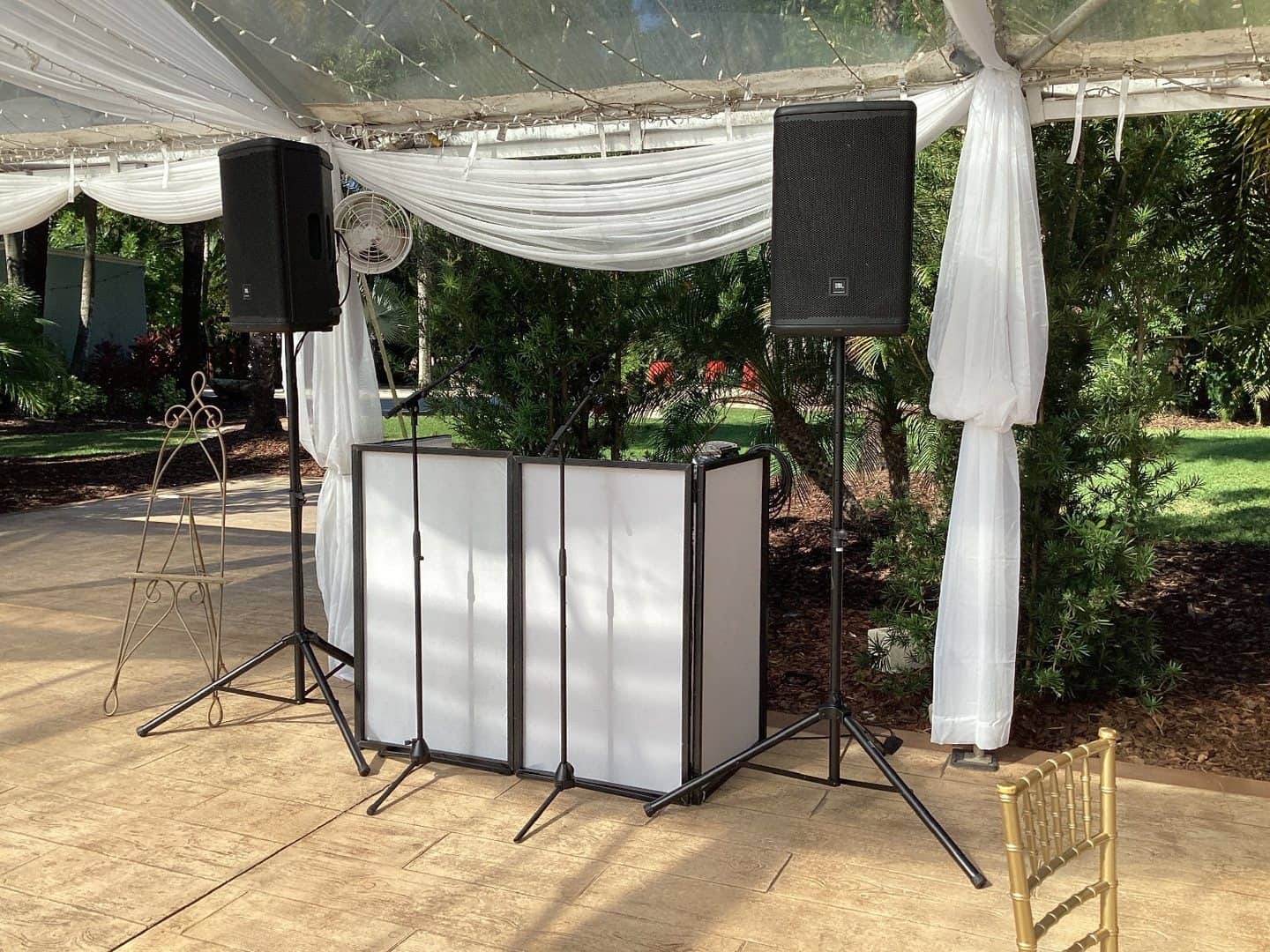 Black cloth DJ facade installed beneath an outdoor event tent
