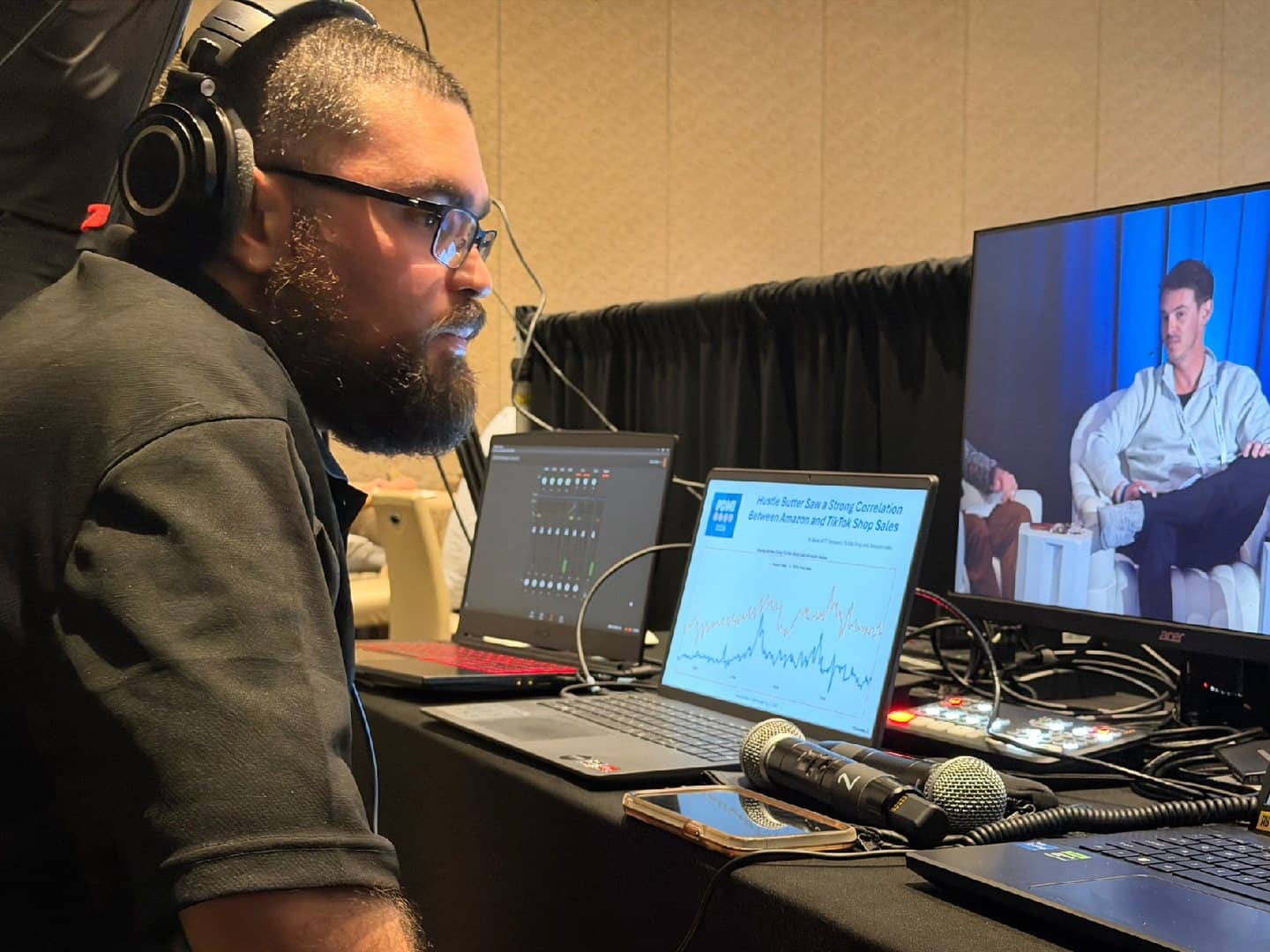 Operator at a multi-laptop production control table; Laptop Stand not pictured