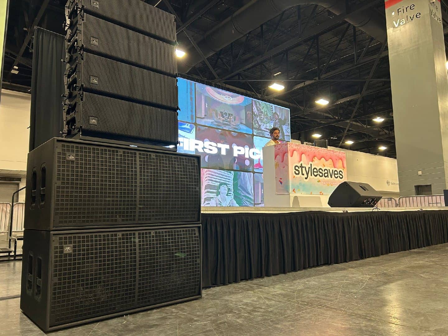 Ground-stacked line array above dual subwoofers at a convention stage