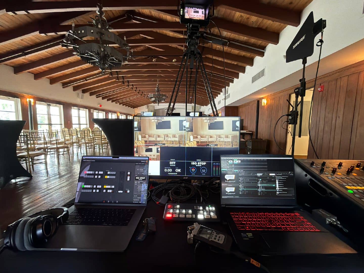 Handheld audio recorder between two laptops at a production control station