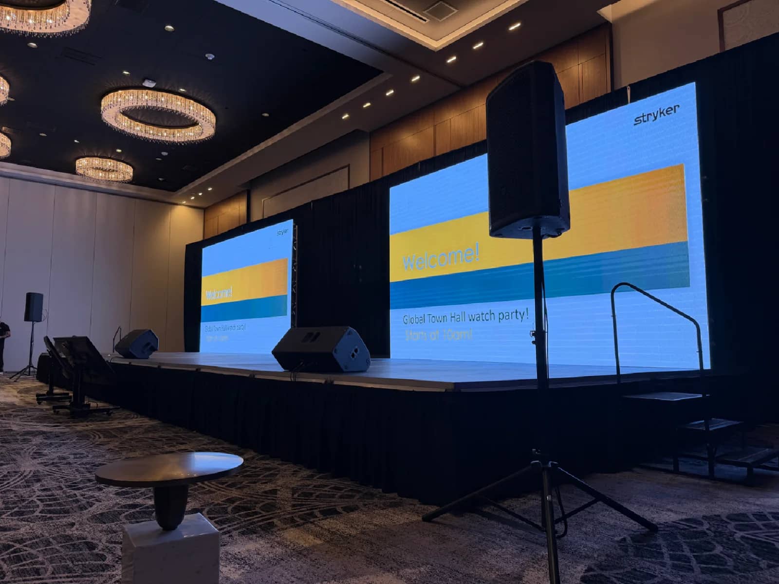 Finished corporate presentation stage with two LED screens, sound system and stairs in a South Florida ballroom