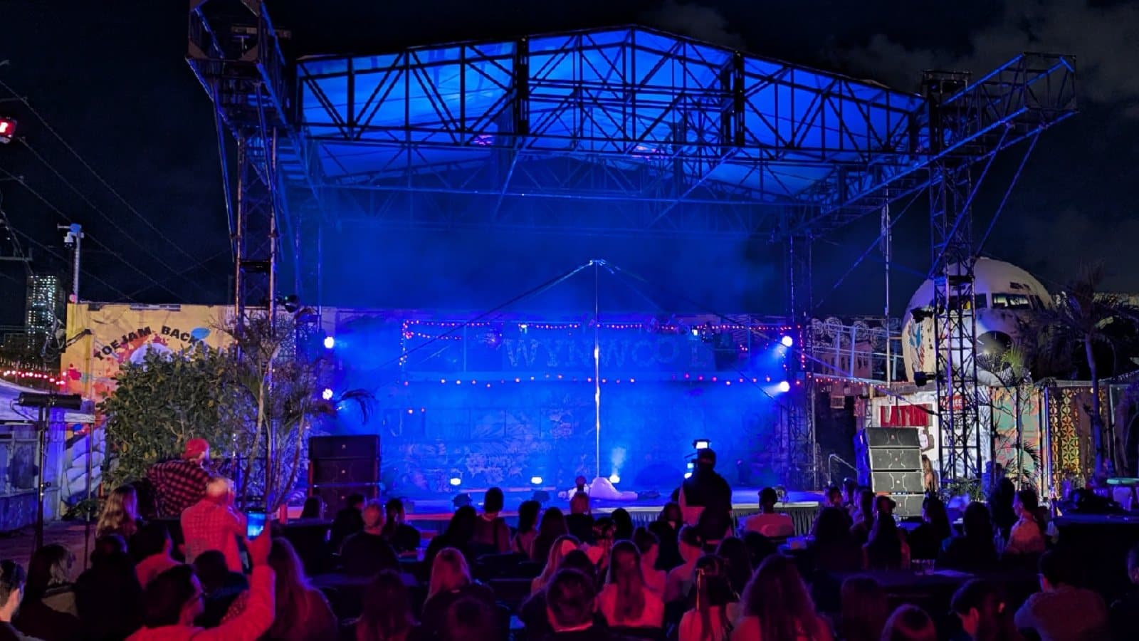Outdoor performance stage washed in blue light before an audience