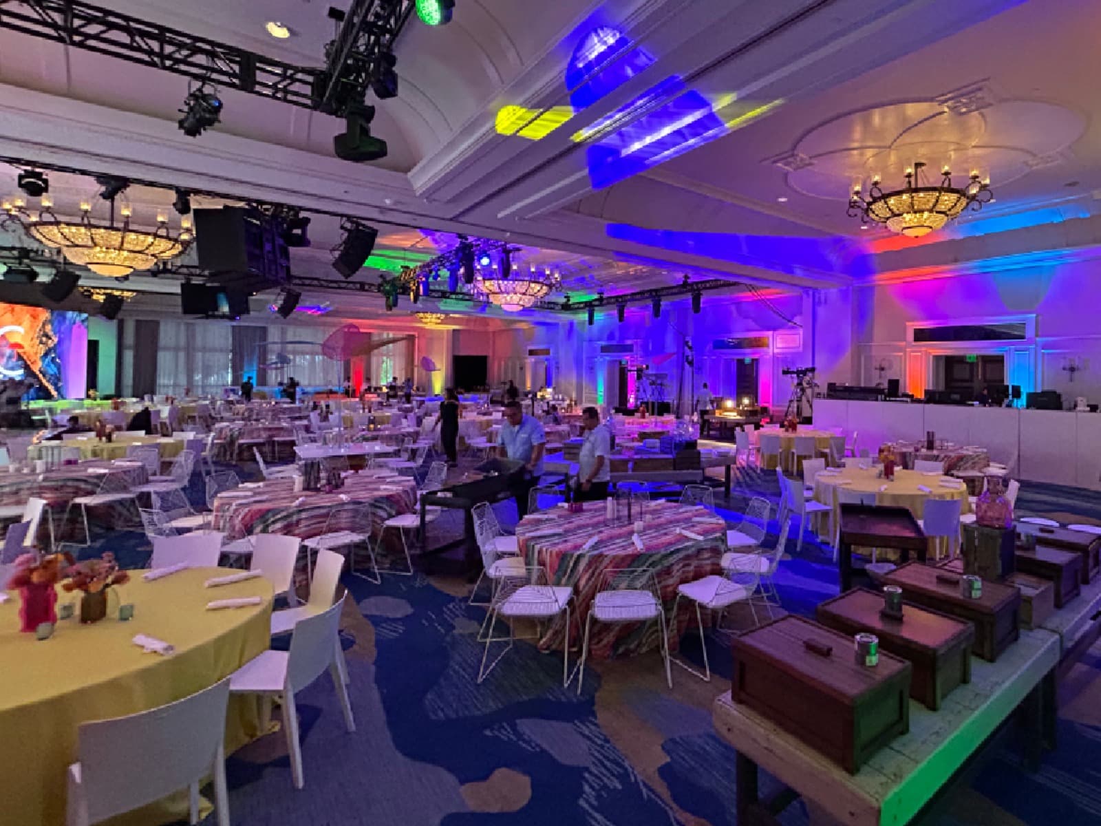 Large ballroom production with room-scale uplighting and an overhead lighting grid