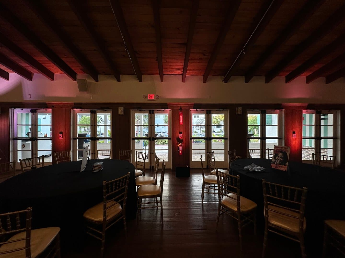 Repeated red uplight columns around an indoor venue