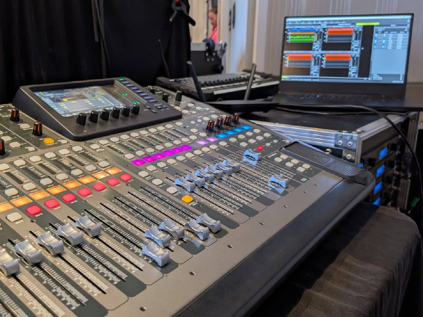 Close view of digital mixer faders and illuminated controls