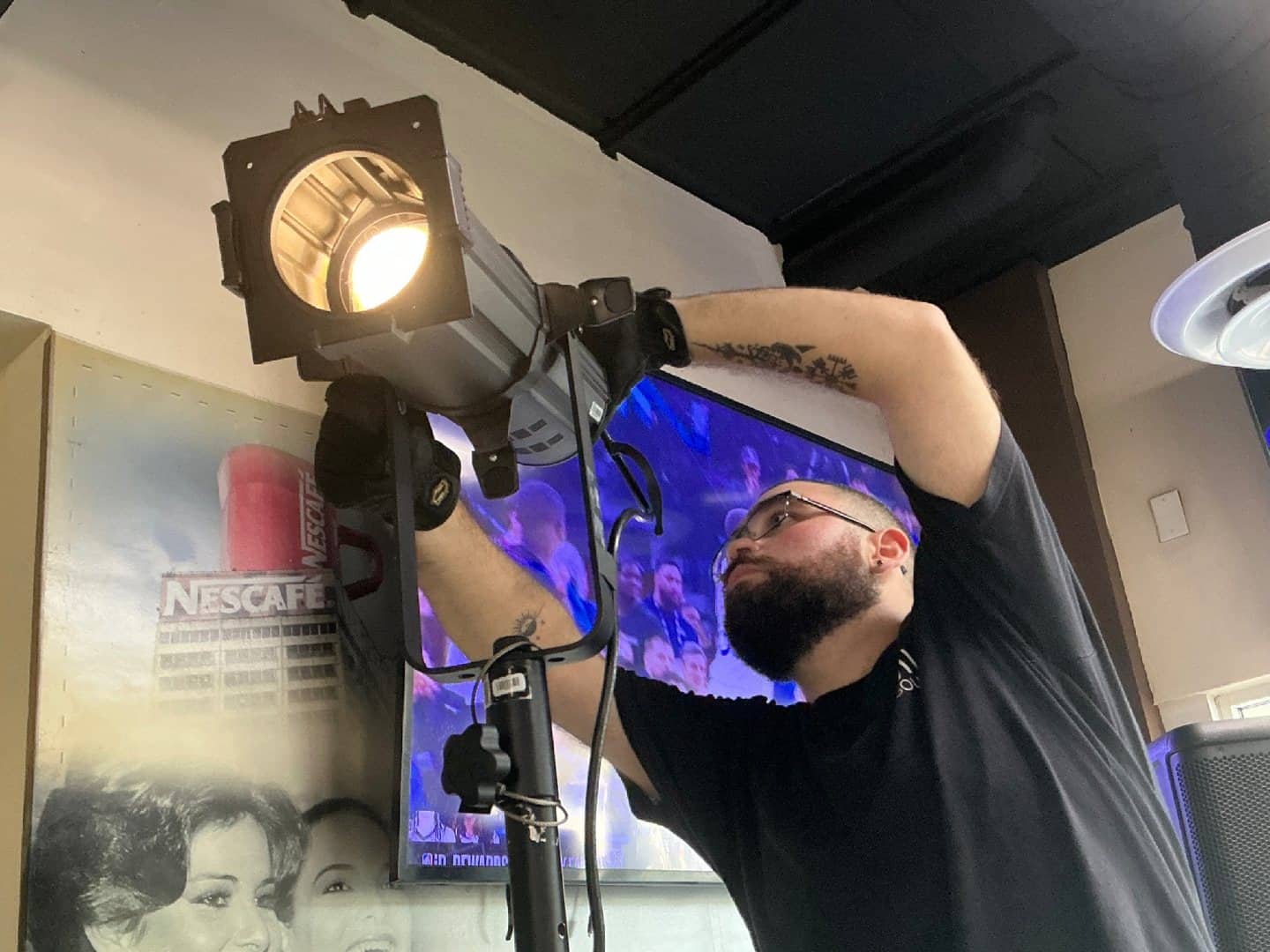 Technician adjusting a spotlight fixture before an event