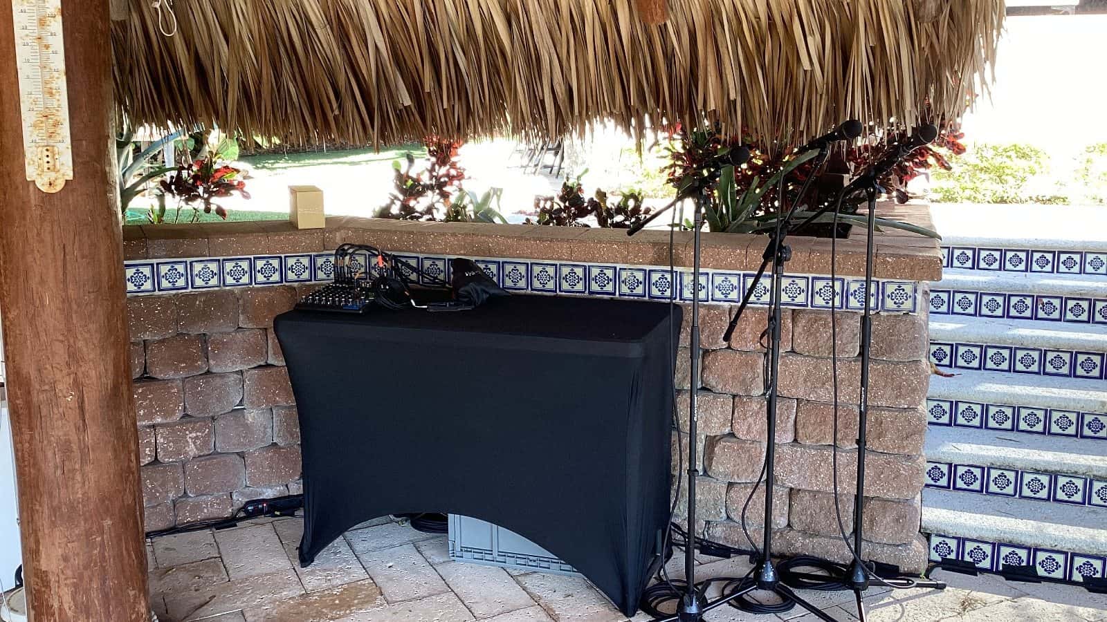 Covered four-foot adjustable table supporting an outdoor audio control position