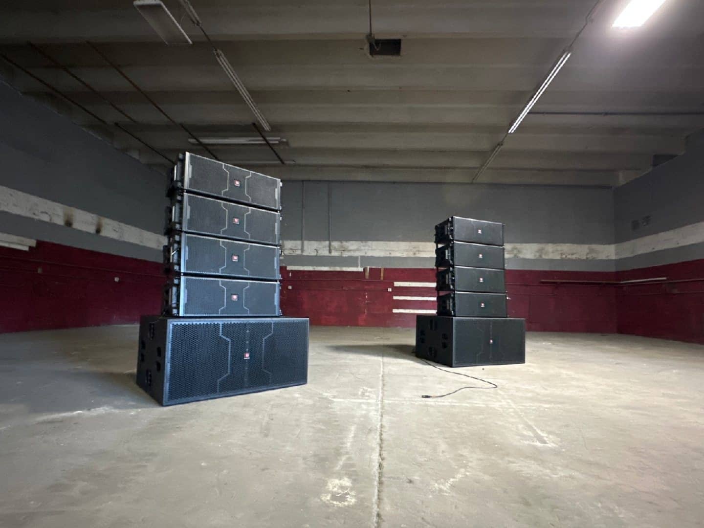 Passive line-array and subwoofer system supported by an off-camera amplifier rack