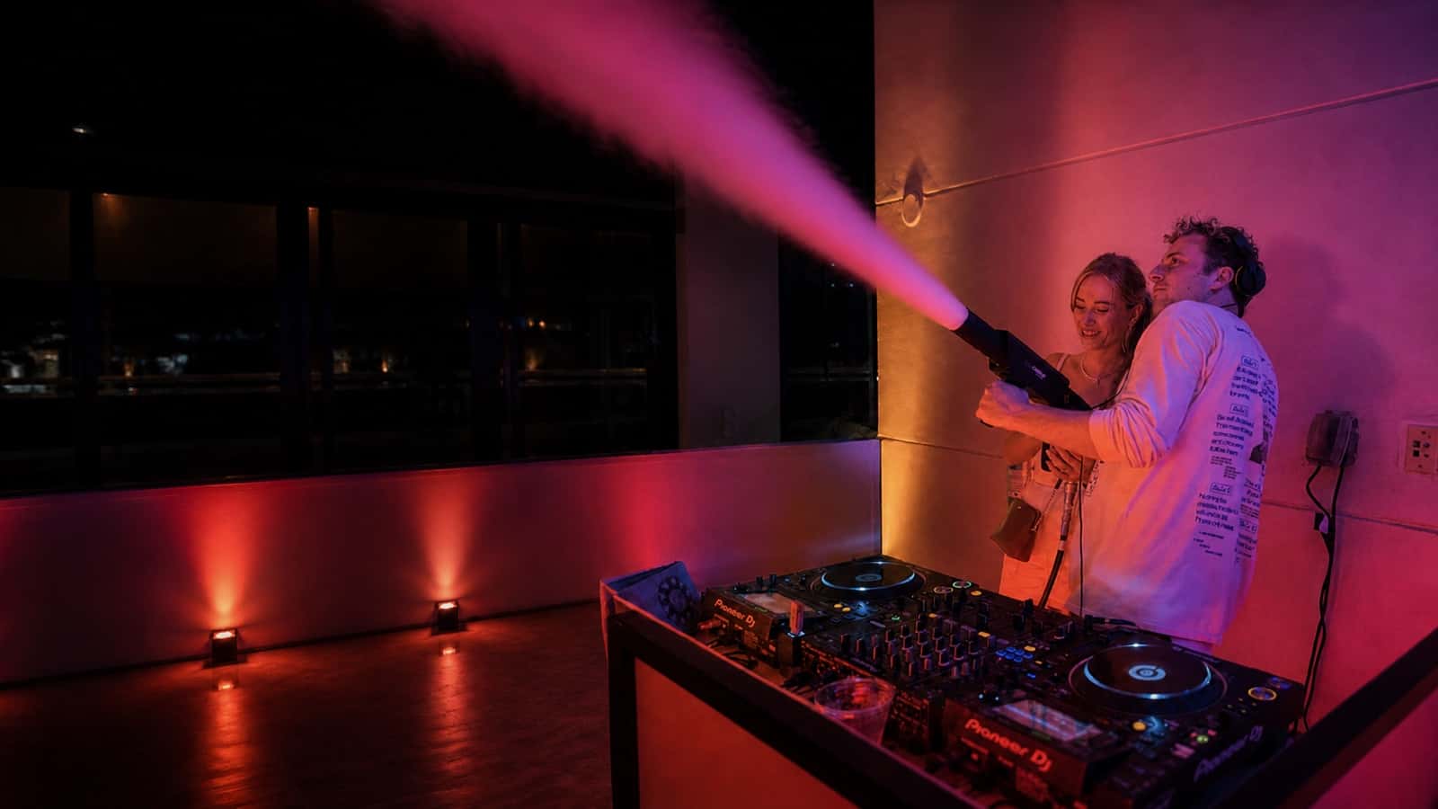 Two operators using a handheld CO2 cannon at a private indoor event