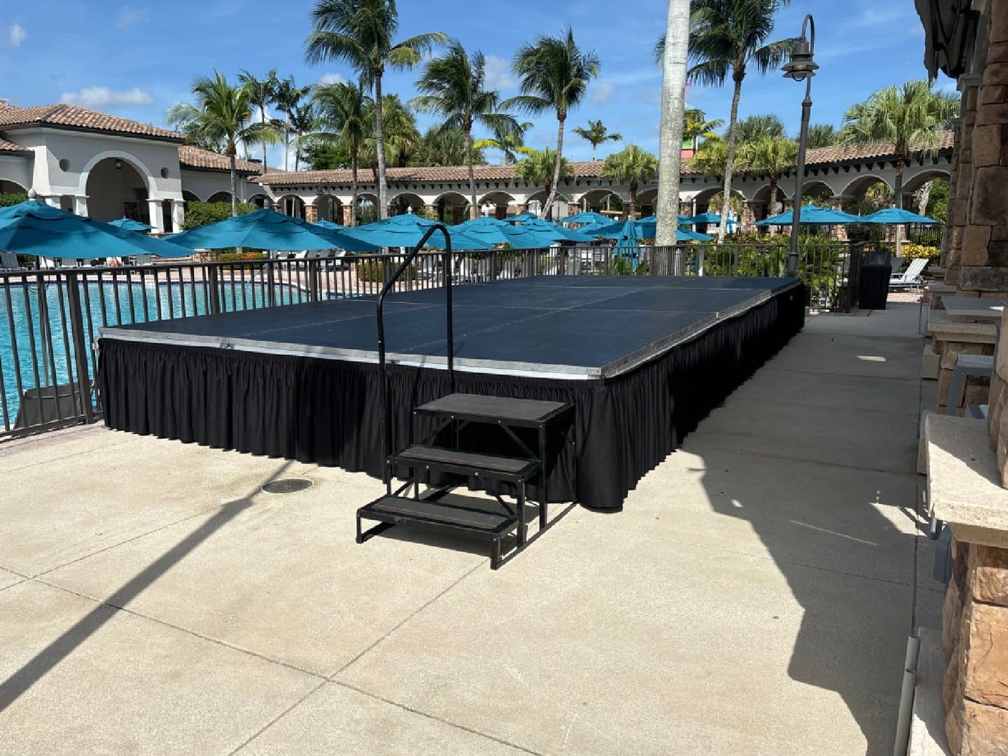 Outdoor portable stage finished with black skirting and access stairs