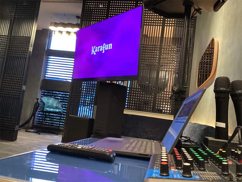 Real karaoke station with two microphones, a television, mixer, and playback controls