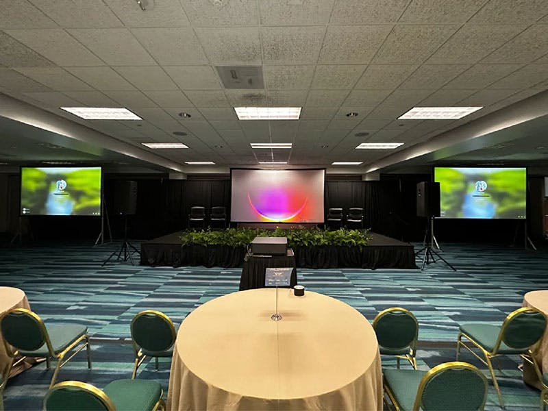 Three projectors with screens on a conference